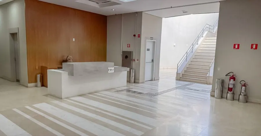 Saguão de recepção da torre, com balcão de atendimento, piso de mármore e escada de acesso aos andares