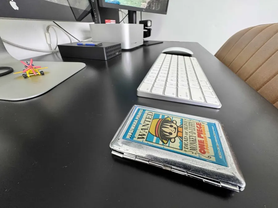 Detalhe da bancada de edição, com teclado e mouse Apple sobre a mesa preta